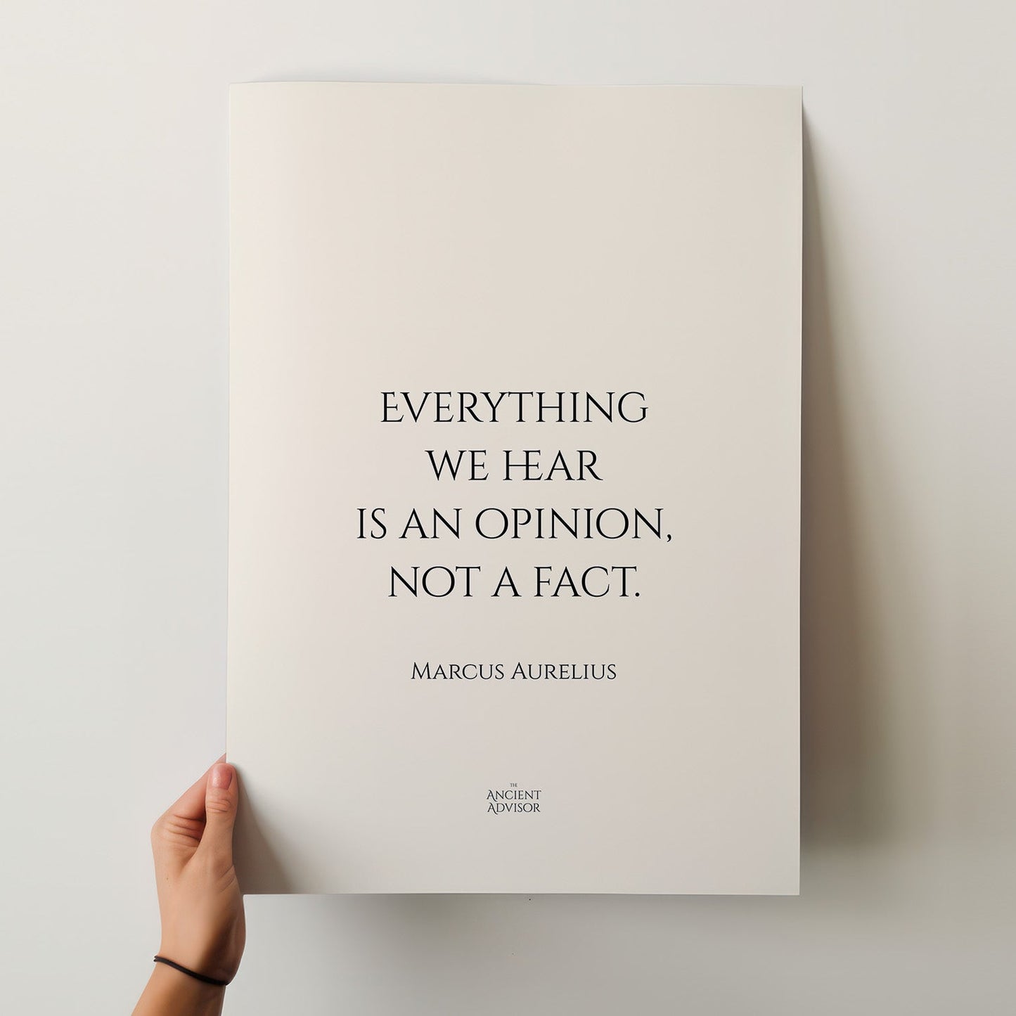 Poster with a quote by Marcus Aurelius held by a hand on a light background